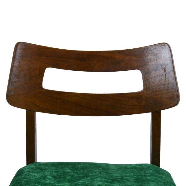 A set of four mid century dining chairs with sculptural open backs and seats newly upholstered in emerald green. The warm...