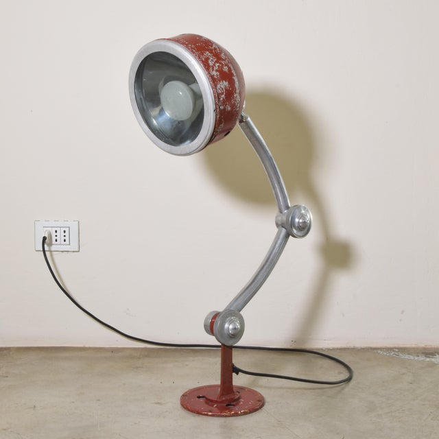 A lamp with a decidedly industrial vintage charm, straight from a mid-twentieth-century machine shop or workshop. It's a...