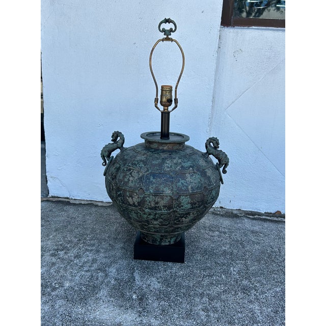 Impressive pair of Asian table lamps crafted in bronze in Bulbous form featuring dragon handles in an alluring verdigris...