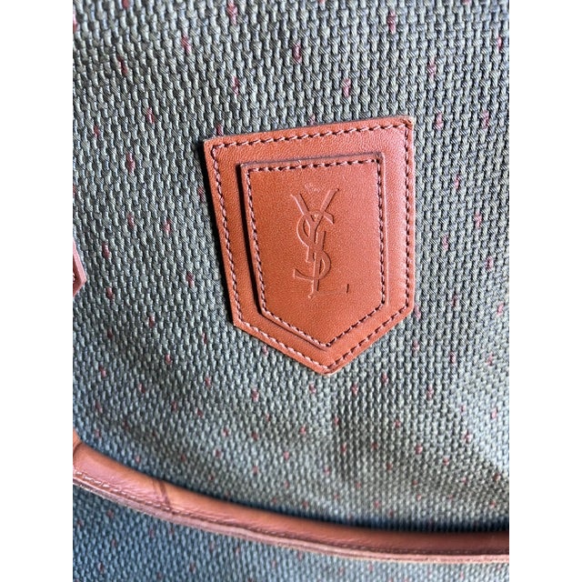 A beautiful vintage Yves Saint Laurent Weekender bag featuring the iconic YSL monogram canvas complemented by rich tan...