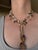 A beautiful handcrafted multi-strand necklace featuring a warm, natural mix of stones and textures. Braided silk gold-tone...