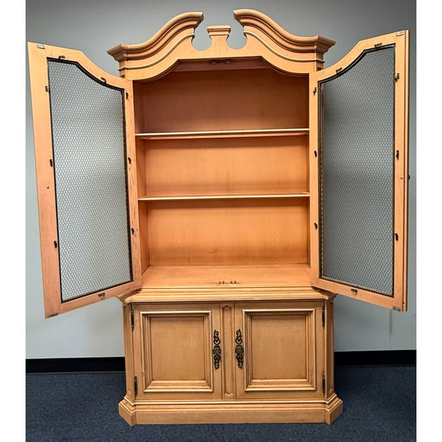 Beautiful Heritage Furniture display cabinet with a warm honey-toned wood finish and elegant European country styling. Its...