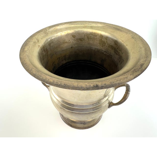 Vintage silverplate champagne cooler with a classic flared form, pedestal base, and dual side handles. The softly aged...