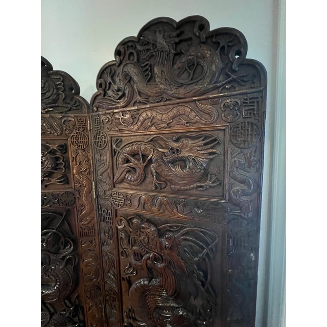 An extraordinary Mid-20th Century Indonesian hand-carved solid teak folding screen showcasing exceptional craftsmanship on...