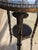 Two tier round accent table with three metal faux bamboo brass legs and elephant heads decor. The table has a leather top.
