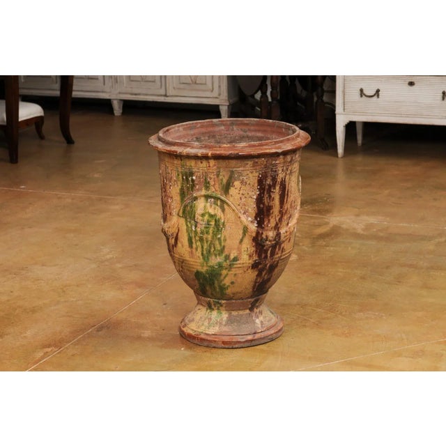 A large French Anduze Boisset jar from the 19th century with dark brown and green drip glaze and swag decoration in raised...