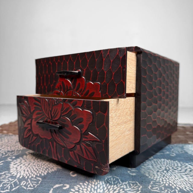 This small cabinet is made in the Kamakura-bori technique: a deep, dark surface with warm red tones revealed in the carved...