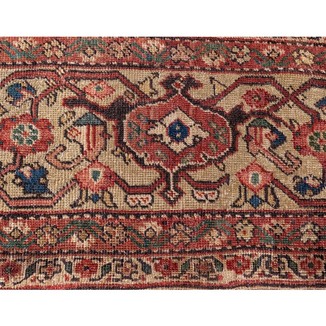This circa-1920 antique Sultanabad rug features an all-over design of floral abstractions in shades of red, brown and...