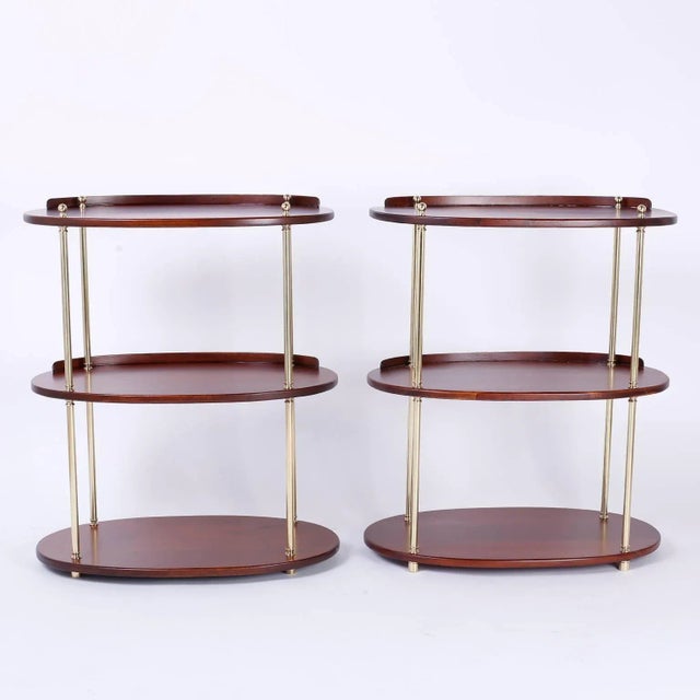 Dashing pair of British Colonial stands with dynamic appeal that can be utilized as servers, bars, or étagères. With three...