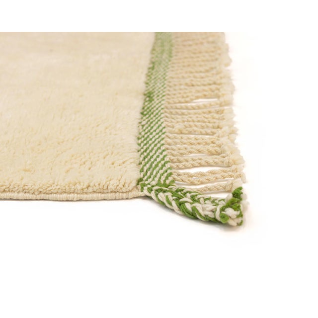 Bold color against a soft ivory canvas — confident, warm, and quietly playful. This hand-knotted wool rug pairs a sharp...