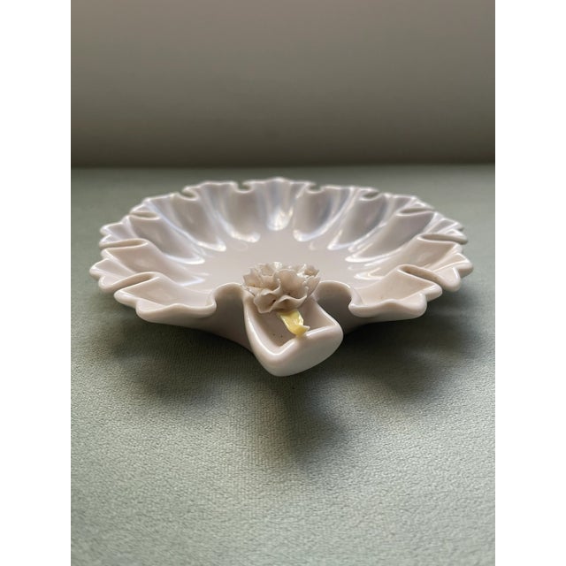 An interesting flat bowl like an elaborately shaped leaf with fluted rufflely edges and a single flower at the stem. This...