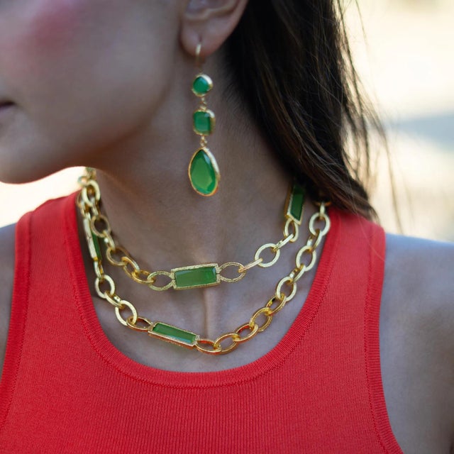 Bring elegance and spiritual energy to your style with these Mystic Green Cat Eye Gold Dangle Earrings. Featuring three...