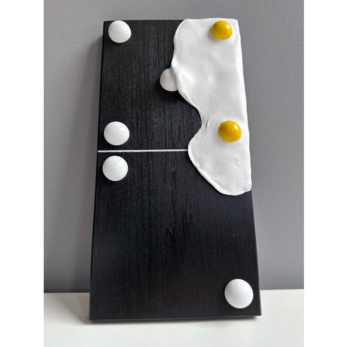 This modular domino wall sculpture is executed in foam clay and acrylic on a black painted wood panel. The composition...