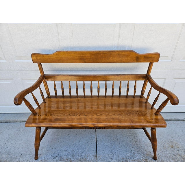 A classic American Colonial style maple bench by Ethan Allen. This two seat bench has a nutmeg finish. The bench features...