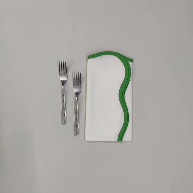 These scalloped white napkins have a contrast color piped around the border - adding a fun twist to your tabletop! Pair...