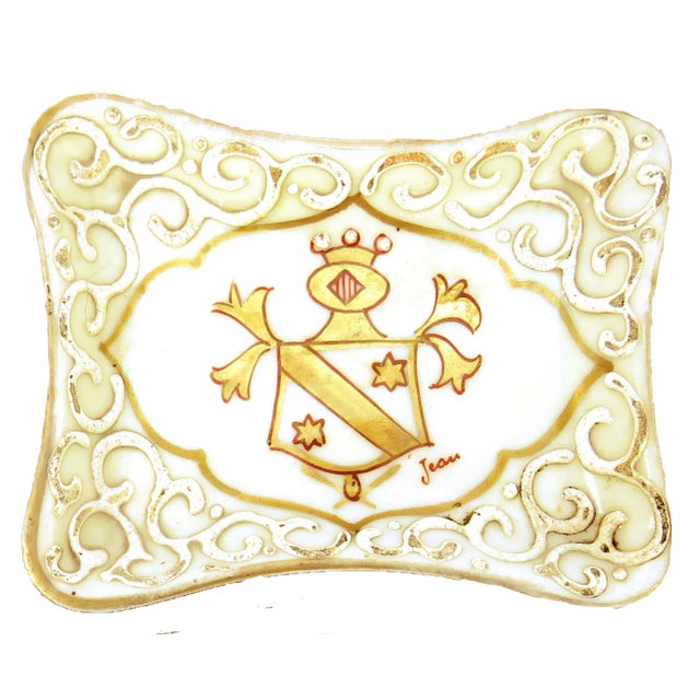 Pair of early 20thC artisan painted porcelain catchalls with a central coat of arms w/ scalloped gilt border surrounded by...