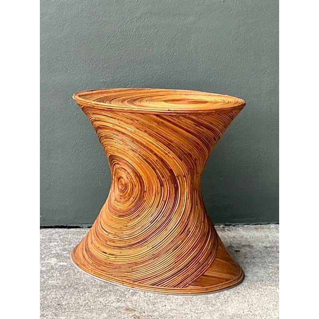 This striking vintage pedestal exemplifies the sculptural possibilities of pencil reed rattan, showcasing a dramatic...