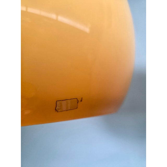 Iconic Space Age floor lamp designed by Luigi Massoni for Guzzini. Features a large amber-colored acrylic glass shade that...