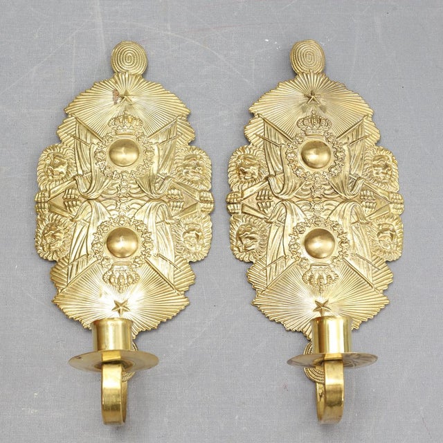 A pair of Swedish brass wall sconces from the early 20th century, featuring a refined neoclassical form with a single...