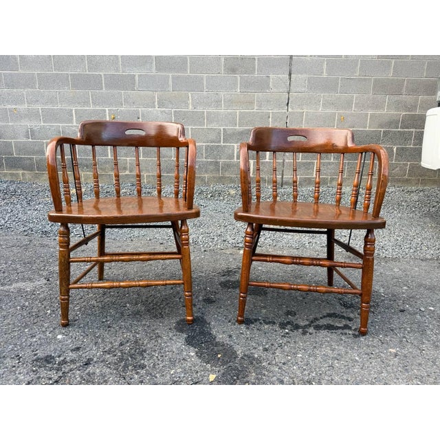 Pair of Heywood Brothers & Wakefield Co. — Philadelphia, PA Barrel Oak Armchairs Antique captain's chairs feature a...