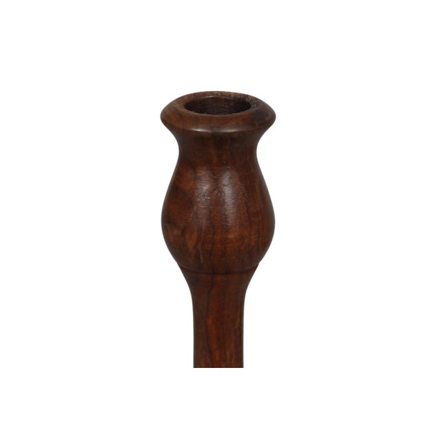A pair of sleek, midcentury modern candlestick holders made of walnut. Elegantly turned columns are topped with tulip...