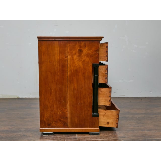 This French Empire walnut commode presents the clean architectural lines and restrained ornamentation associated with the...