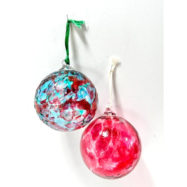 A set of 2 hand-blown, artisan made Christmas ornaments. The swirls of color are beautiful! They were definitely made by a...