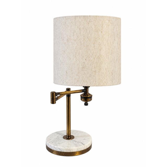 A stylish vintage swing-arm table lamp combining clean modernist lines with warm metallic detailing and a substantial...