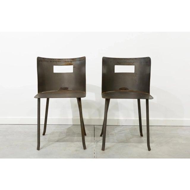 - Pair of industrial chairs - Entirely made of iron - Curved backrest with central window and four legs Labeled by...