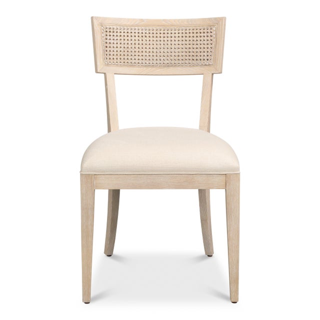 Woven cane arcs across the crest rails of pale ash frames finished as bleached oak, with swept legs recalling the klismos...