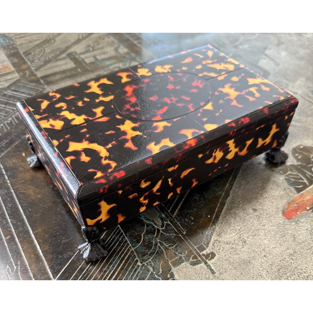Faux tortoise shell rectangular box. Marbled paper interior. On decorative metal feet.