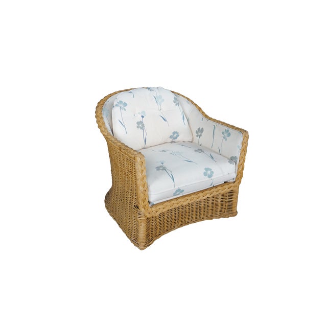 Embodying a relaxed coastal or bohemian aesthetic, this vintage woven wicker barrel-back armchair features a highly...