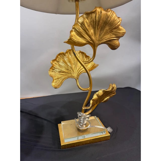 An elegant and highly decorative pair of gilt bronze table lamps modeled as gracefully intertwining ginkgo branches with...