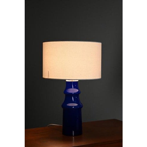 Johansfors table lamp made of bright blue glass. The shade is nog original and can be switched with your own shade. The...