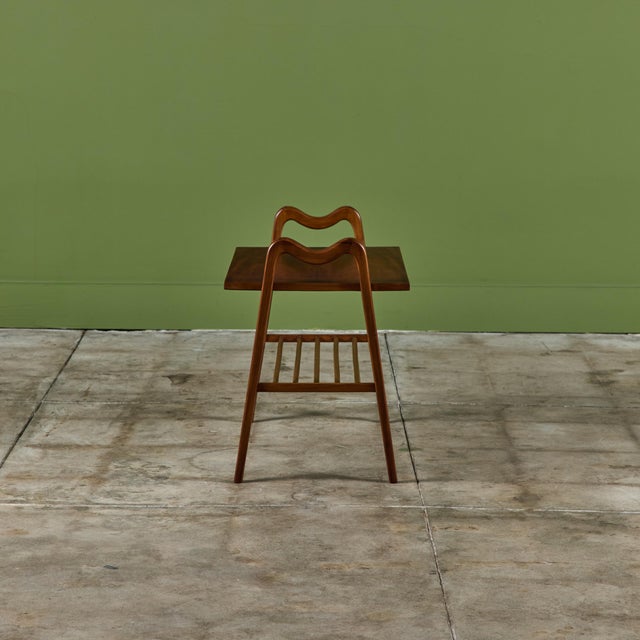 Two-tier side table in the style of Ico Parisi. The walnut table features a bottom spindle shelf and rectangular table...