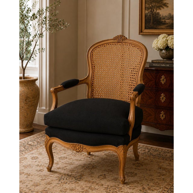 A beautifully proportioned French Louis XV–style bergère armchair featuring an original carved wood frame, elegant...