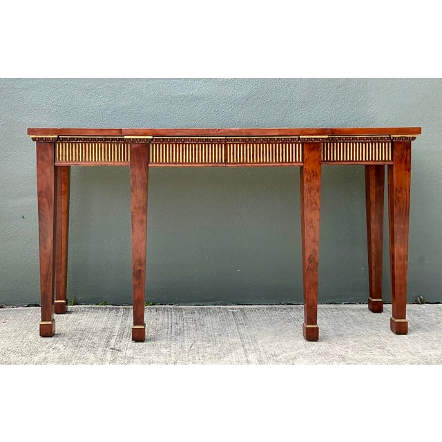 This grand Neoclassical breakfront console table is a masterclass in architectural elegance and traditional...