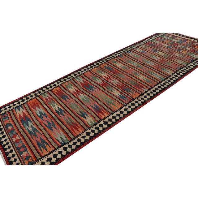 Handwoven in wool, circa 1950-1960, this 5x14 vintage Afghani tribal kilim rug, is nearly a gallery runner-sized artwork....