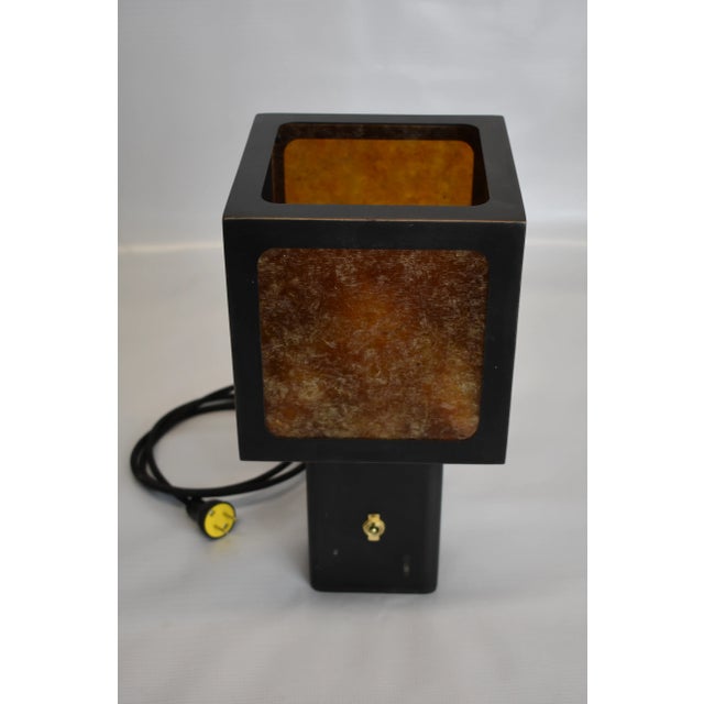 Blackened steel table lamp with amber mica paneling. Antique black patina finish with bronze accents. The idea for this...