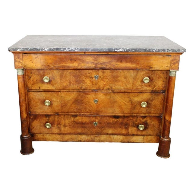 19th-century French Empire commode, crafted in luxurious burled walnut, exemplifies the elegance and stately beauty of the...