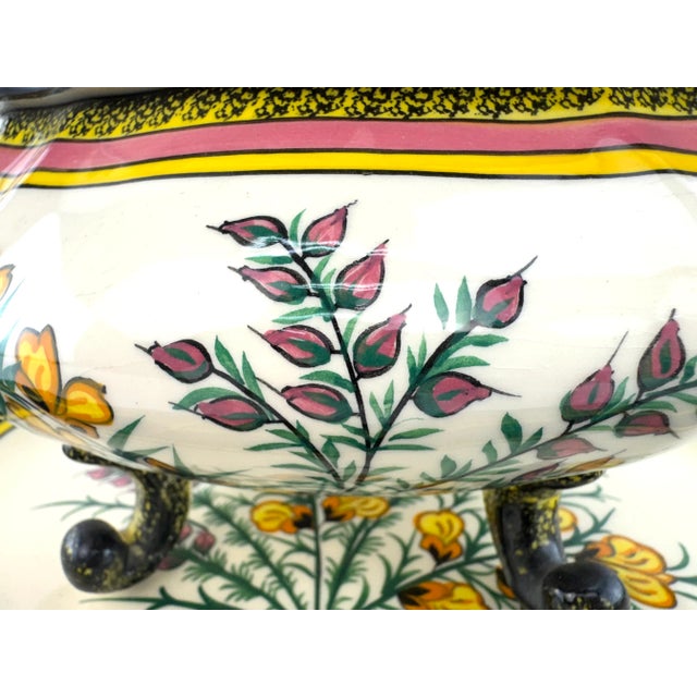 A vibrant hand-painted faience soup tureen with matching underplate from Henriot Quimper, France, showcasing the region's...