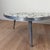 A sculptural mid-century coffee table with a flowing, kidney-shaped silhouette and mosaic glass tile top. The surface...