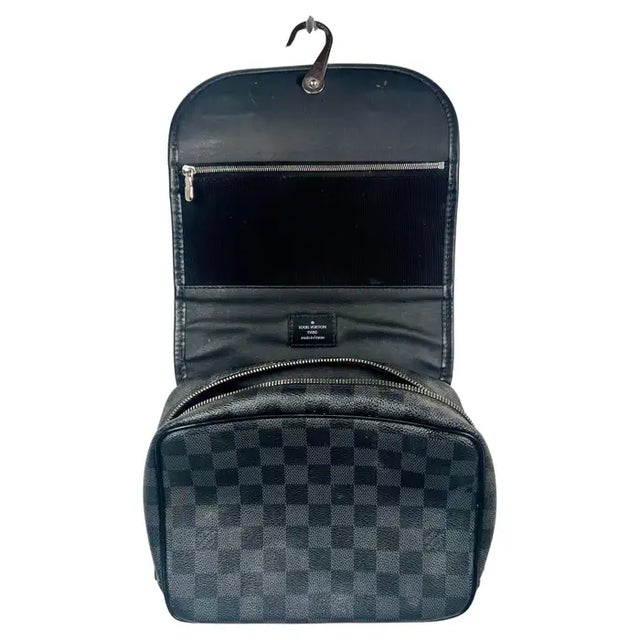 This Louis Vuitton Damier Graphite Hanging Toiletry Case is a sleek and highly functional travel essential, crafted in the...