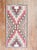 A highly decorative 20th-century American Navajo rug with a geometric tribal design with pink, cream ,camel and brown...
