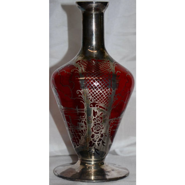 This is a lovely Art Nouveau vase formed of ruby red glass with a delicate silver overlay. Dainty lattice work tops an...