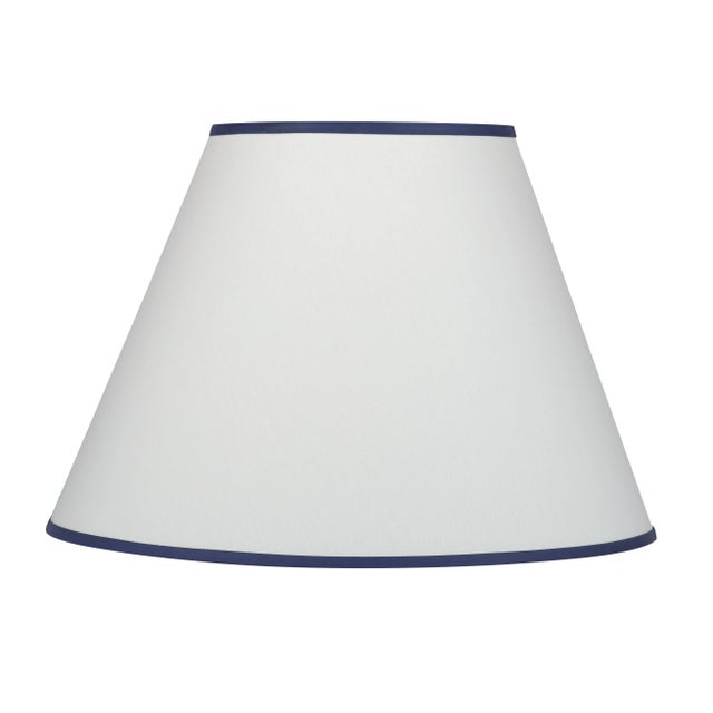 A cream colored hard-backed fabric empire shade with navy trim ‚Äì an easy way to bring together similar colored elements...