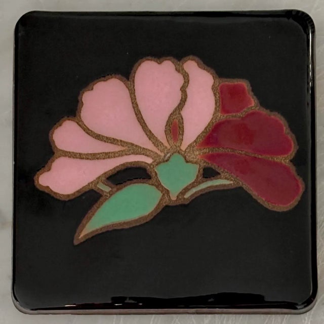 Art Deco style flower trivet coaster, with pink and maroon on a black background. Tabletop is protected by cork pads. I...