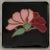 Art Deco style flower trivet coaster, with pink and maroon on a black background. Tabletop is protected by cork pads. I...