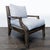 This Kreiss lounge chair features a sturdy wood frame with gently curved arms and thick, comfortable light grey cushions....