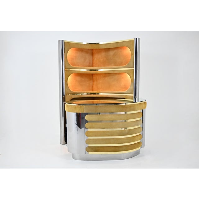 The set includes a cabinet with three illuminated shelves in suede, chrome, and brass. It also includes a counter in suede...